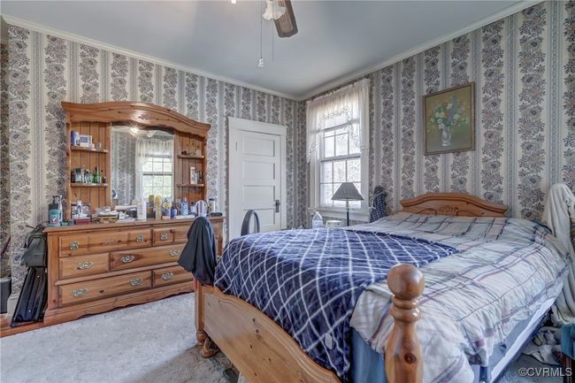 Bedroom with wallpapered walls, crown molding, ceiling fan, and carpet | Image 24