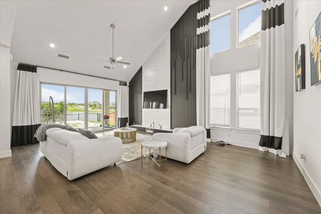 Living area with high vaulted ceiling, healthy amount of natural light, ceiling fan, recessed lighting, and dark wood-type flooring | Image 5
