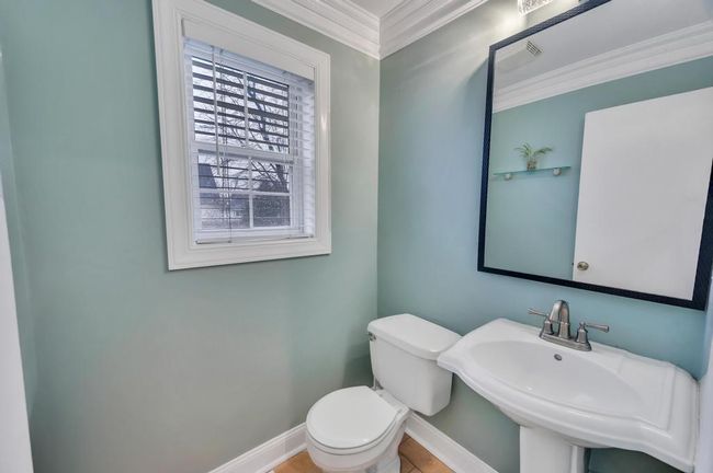 Bathroom with toilet, ornamental molding, baseboards, a sink, and visible vents | Image 18