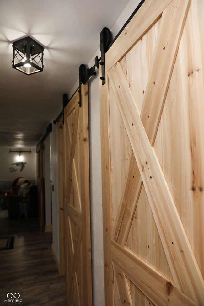 corridor with a barn door and wood finished floors | Image 10