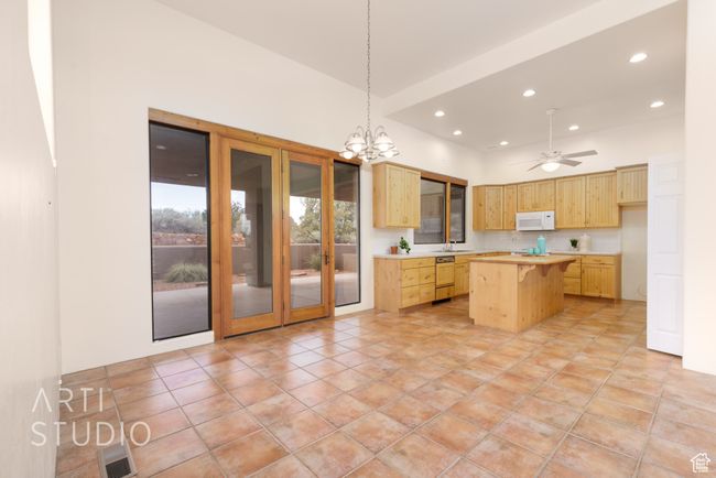 Kitchen featuring light countertops, light brown cabinets, white microwave, and a kitchen island | Image 17