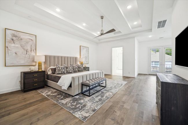 PRIMARY BEDROOM: Thoughtfully designed with comfort and sophistication in mind, this spacious retreat offers a serene escape from the hustle and bustle of daily life. The room is adorned with sophisticated ceiling details that add a touch of architectural elegance, setting it apart as a true retreat within the home. | Image 30