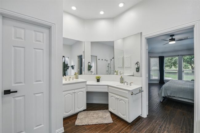 Bathroom featuring double vanity, a ceiling fan, wood finished floors, ensuite bathroom, and recessed lighting | Image 22