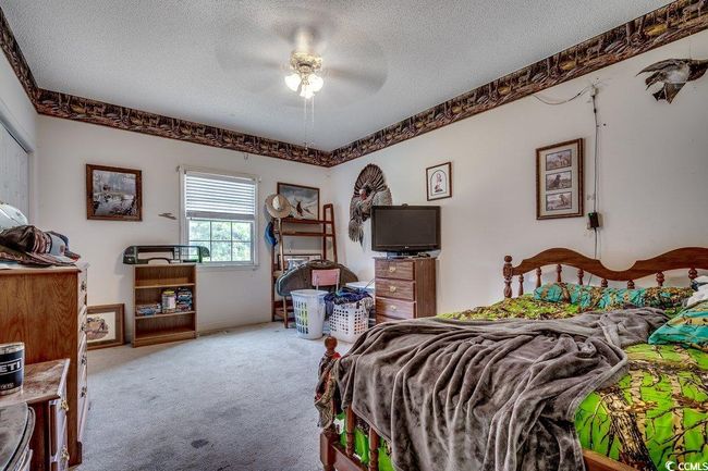Bedroom featuring a textured ceiling, carpet floors, and a ceiling fan | Image 20