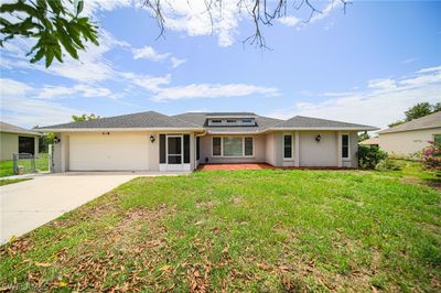 Ranch-style house featuring a front lawn and a garage | Image 1