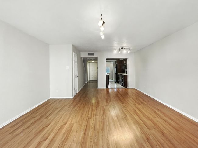 Unfurnished living room featuring light wood-type flooring and track lighting | Image 6