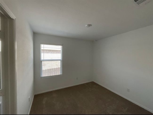 Unfurnished room with dark colored carpet and baseboards | Image 11