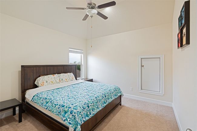 Bedroom featuring light colored carpet, ceiling fan, and lofted ceiling | Image 31