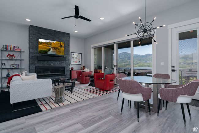 Dining area featuring wood finished floors, a chandelier, a fireplace, a mountain view, and recessed lighting | Image 6