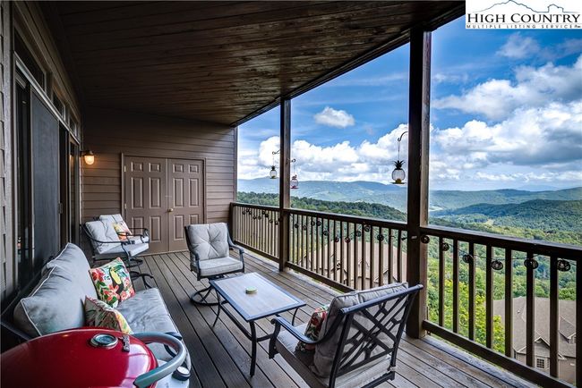 Expansive covered deck and walls of sliding glass doors provide expanded living space in any season. Notice the large walk in storage room at one end. | Image 7