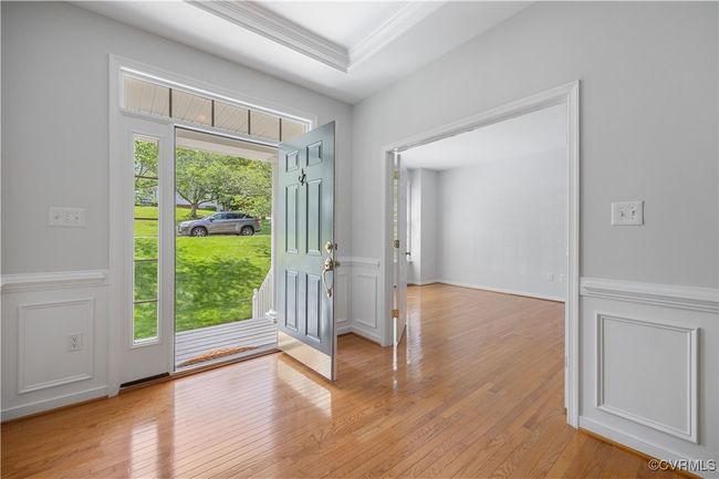 Foyer entrance with a wainscoted wall, light wood-style flooring, and a decorative wall | Image 8
