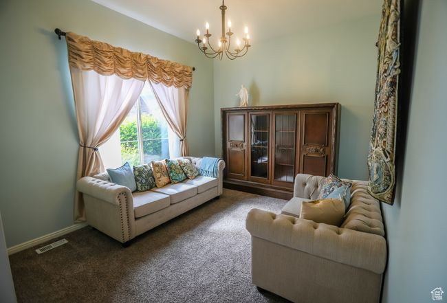 Living area featuring a chandelier and dark carpet | Image 17