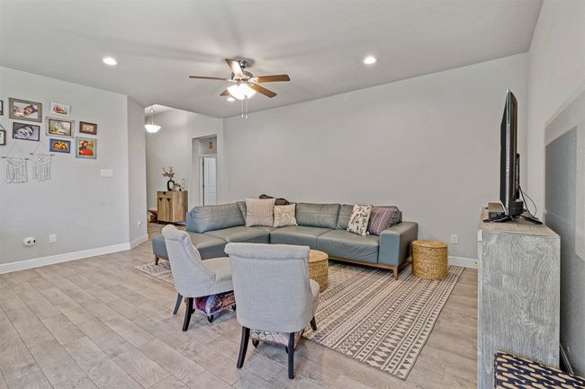 Living area with a ceiling fan, light wood-style flooring, and recessed lighting | Image 4