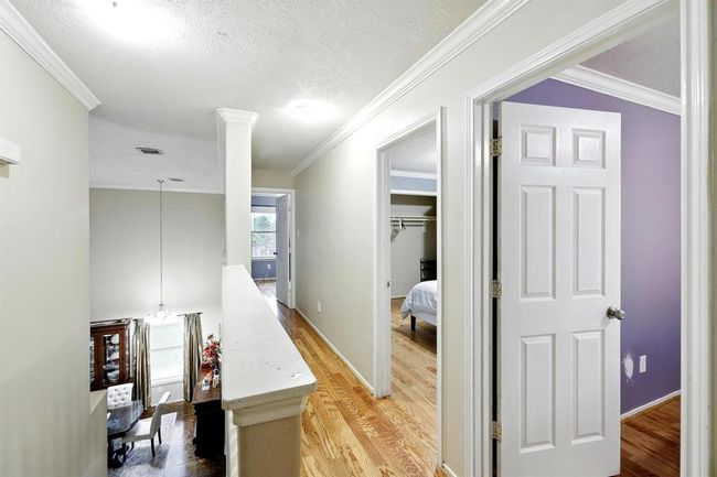 Upstairs landing offers a bright, open layout with a view overlooking the formal dining area below. Crown molding and wood flooring enhance the space, providing access to all secondary bedrooms. | Image 13