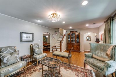 Living room featuring crown molding, a chandelier, and light wood-type flooring | Image 2