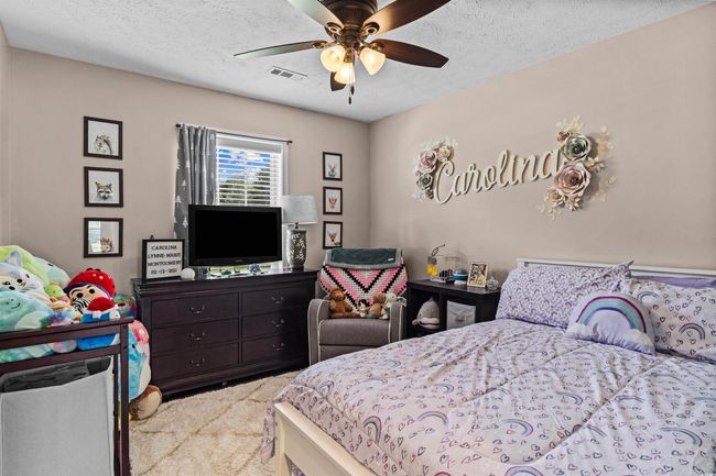 Bedroom with light carpet, a textured ceiling, and a ceiling fan | Image 13