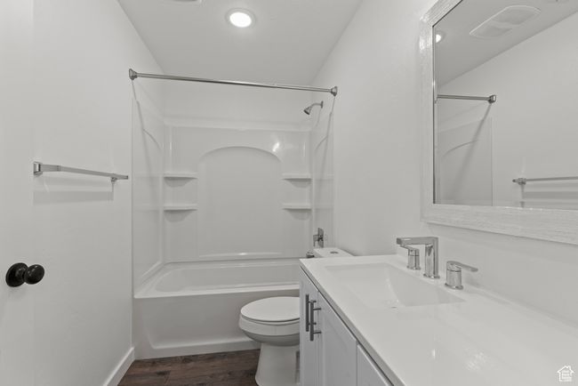Full bath with wood finished floors, toilet, vanity, shower combination, and baseboards | Image 34