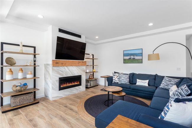 Living room featuring baseboards, recessed lighting, a fireplace, and light wood-style floors | Image 4