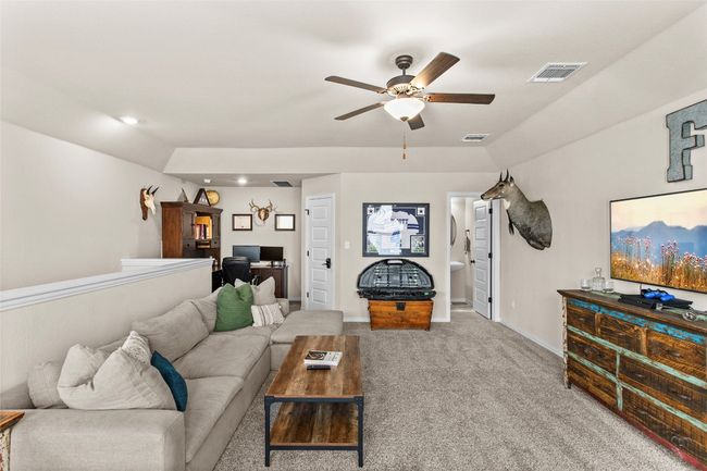 Carpeted living area featuring ceiling fan, recessed lighting, and an office area | Image 25