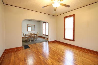 Unfurnished room with wood-type flooring, plenty of natural light, ornamental molding, and ceiling fan | Image 3