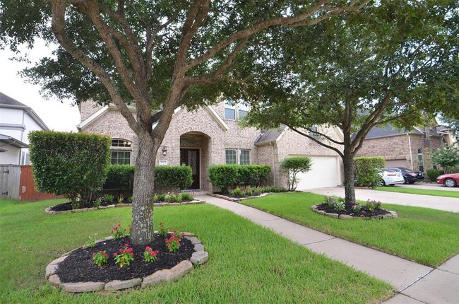 Well-maintained front yard with shrubs and mature trees and mature trees and mature trees. | Image 4
