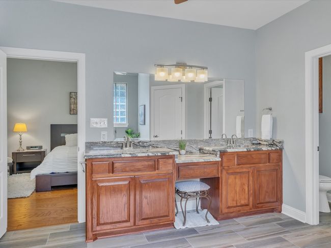 Bathroom featuring ensuite bathroom, toilet, double vanity, wood finished floors, and baseboards | Image 23