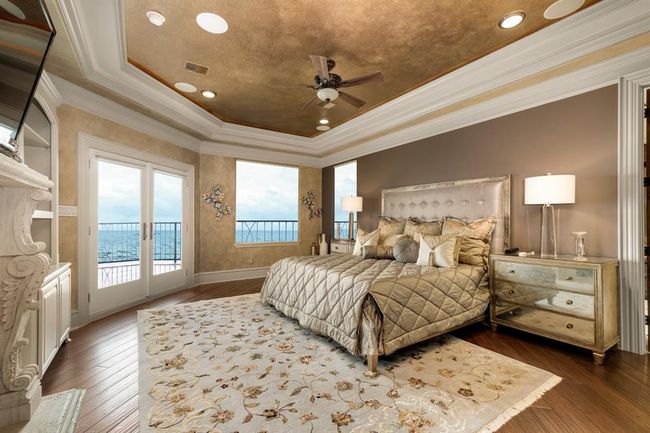 primary bedroom has views of the bay, built in shelving, alcove ceiling with accent lighting | Image 26