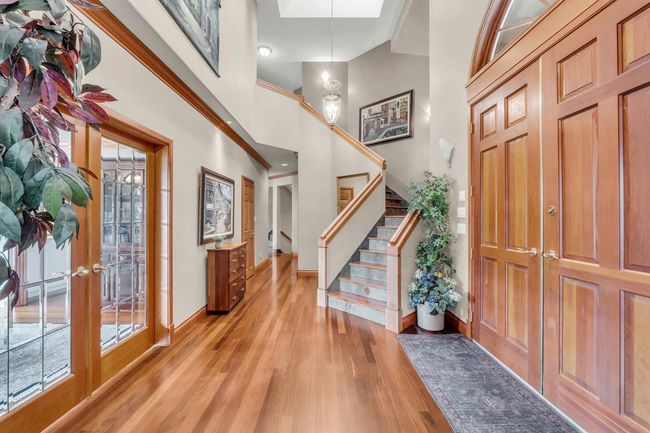 Entrance foyer featuring baseboards, a wealth of natural light, stairway, and light wood finished floors | Image 12