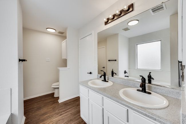 Bathroom with double vanity, toilet, wood finished floors, and baseboards | Image 34