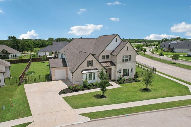 View of front facade featuring concrete driveway, stone siding, a standing seam roof, roof with shingles, and a residential view | Image 30