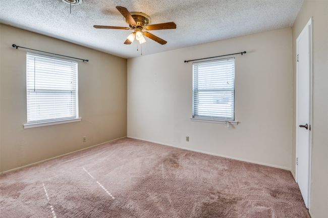 Carpeted spare room featuring ceiling fan and a textured ceiling | Image 21