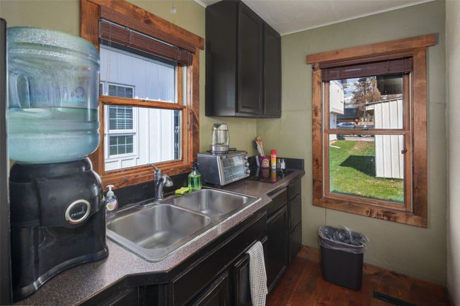 Kitchen with a sink, plenty of natural light, a toaster, dark wood finished floors, and dark cabinetry | Image 14