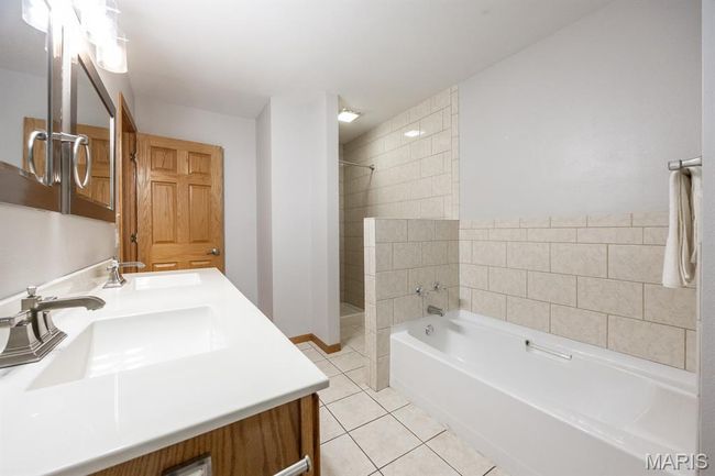 Bathroom featuring double vanity, tile patterned floors, a garden tub, and a shower | Image 24