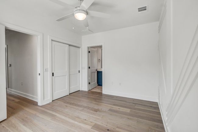 Unfurnished bedroom featuring light wood finished floors, baseboards, ensuite bathroom, and a closet | Image 15