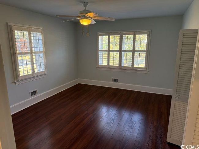 Unfurnished room with dark wood-type flooring, ceiling fan, and plenty of natural light | Image 21
