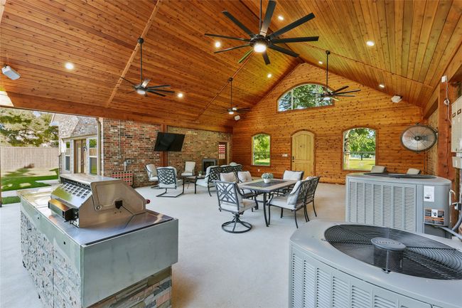 View of cedar lined pavillion featuring 4 large ceiling fans, connected to pool house with garage access | Image 27