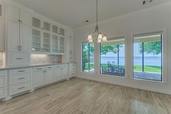 The back wall of the dining space was redesigned with large picture windows to maximize the lake views. These also have shades offering the flexibility to raise or lower for both privacy and light control. | Image 19