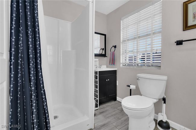 Full bathroom featuring vanity, baseboards, a shower stall, and toilet | Image 22
