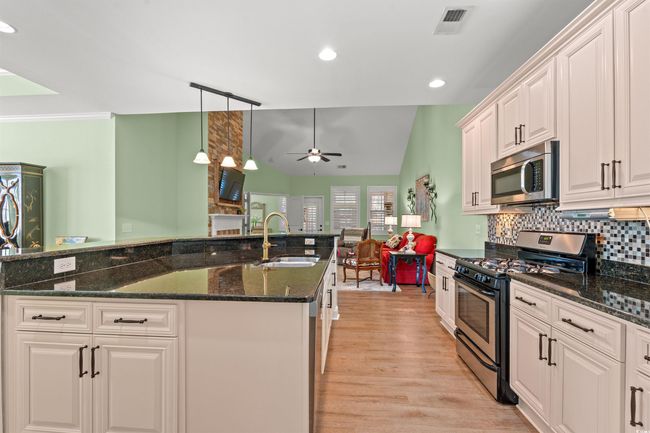 Kitchen featuring visible vents, a ceiling fan, tasteful backsplash, appliances with stainless steel finishes, and a sink | Image 11