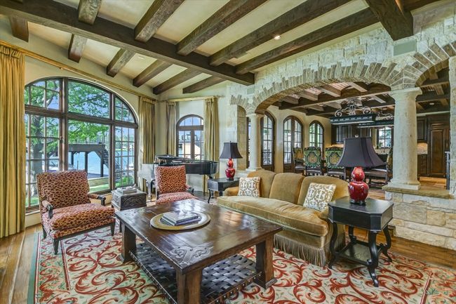 Living area with decorative columns, hardwood / wood-style floors, beam ceiling, and arched walkways | Image 8