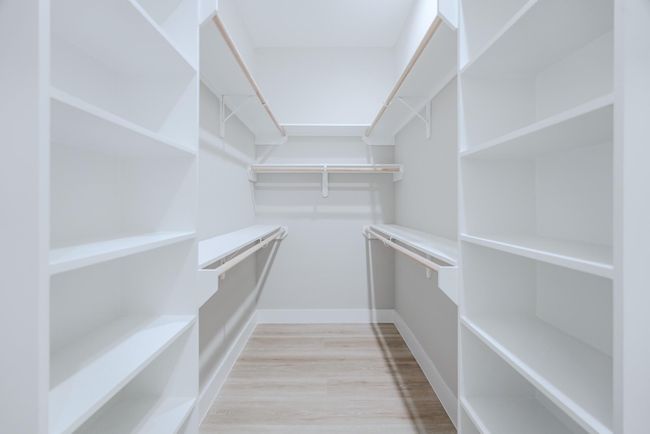 Expansive walk-in closet offers custom storage solutions in primary suite | Image 27