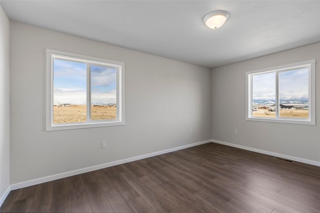 Spare room with dark wood-style floors, visible vents, and baseboards | Image 45