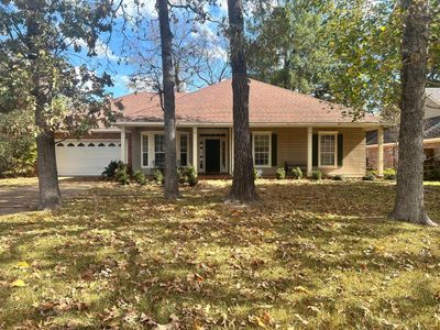 Ranch-style home featuring a front lawn and a garage | Image 1