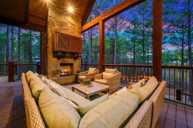 Sunroom / solarium featuring lofted ceiling, an outdoor stone fireplace, and a wealth of natural light | Image 5