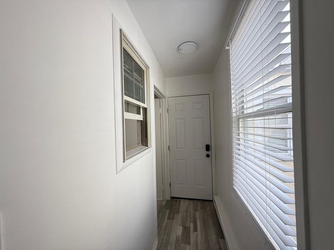 Doorway to outside bedroom to the left with wood finished floors | Image 9