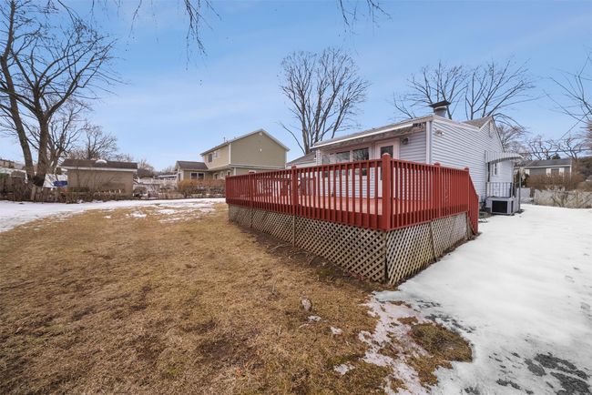 Snow covered back of property featuring central AC and a wooden deck | Image 41