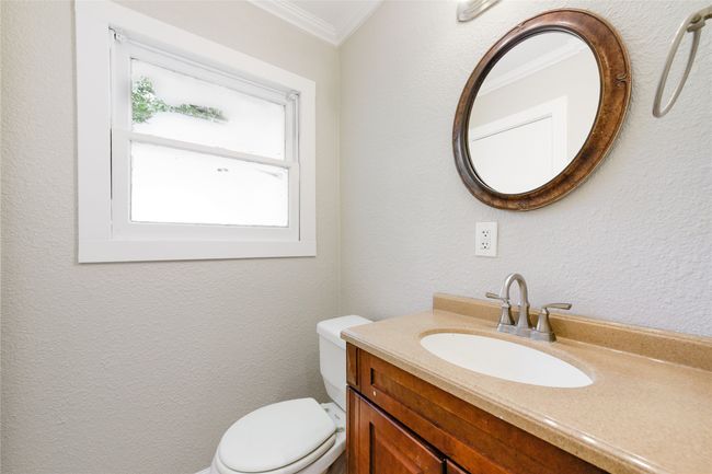 Bathroom featuring crown molding, vanity, and a textured wall | Image 32