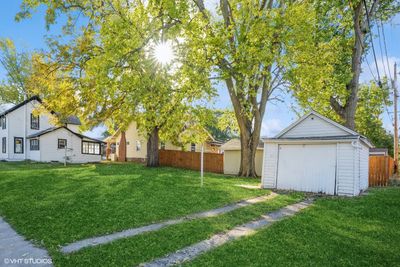 Backyard and Garage: A spacious backyard with mature trees and a one-car detached garage, perfect for outdoor activities and extra storage. | Image 3