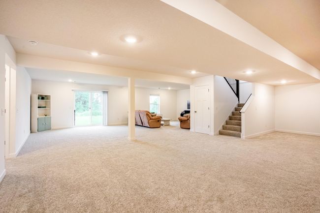 Expansive finished walkout basement with plush carpeting and versatile open space—ideal for entertaining or relaxing. | Image 31
