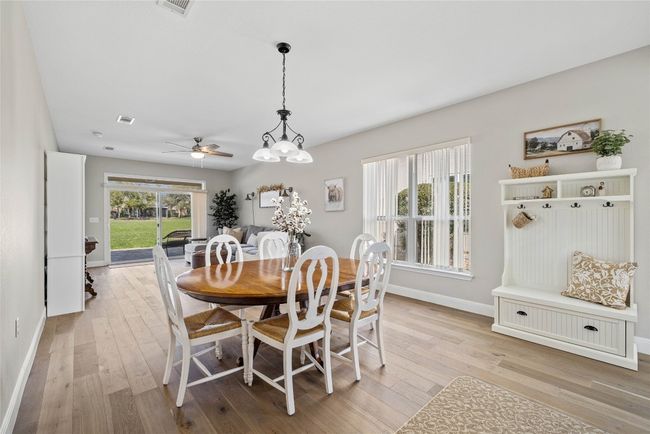 Dining space featuring baseboards, visible vents, light wood-style flooring, and a ceiling fan | Image 6